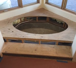 A large wooden tub sitting in the middle of a room.