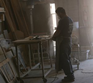 A man standing in front of a table with a saw.