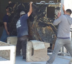 A group of men working on a marble wall.