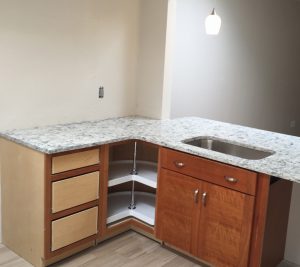 A kitchen with an empty counter and cabinets.