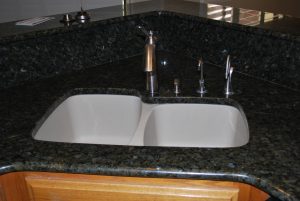 A kitchen sink with two sinks and a faucet.